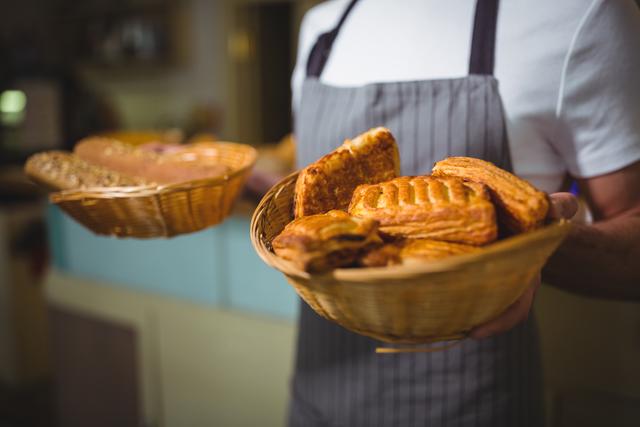 Waiter holding baskets filled with fresh bread and pastries in a cafe. Ideal for use in food blogs, bakery advertisements, restaurant menus, and culinary websites to showcase fresh baked goods and professional service.