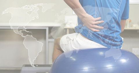 Sitting on stability ball touching lower back rehab session improving posture