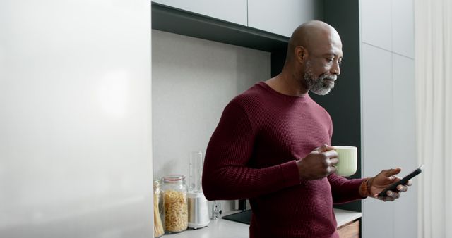 Mature Man Holding Coffee Mug Checking Smartphone in Modern Kitchen - Download Free Stock Images Pikwizard.com