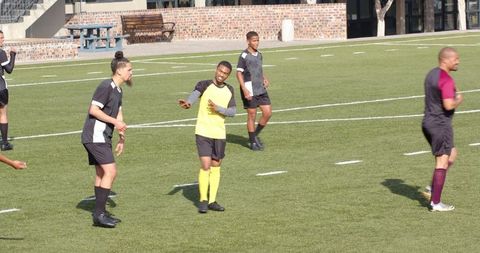 Soccer players competing intensely on green field