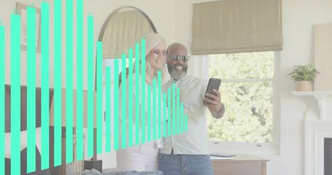 Senior couple taking smartphone selfie in bright bedroom with teal data chart overlay