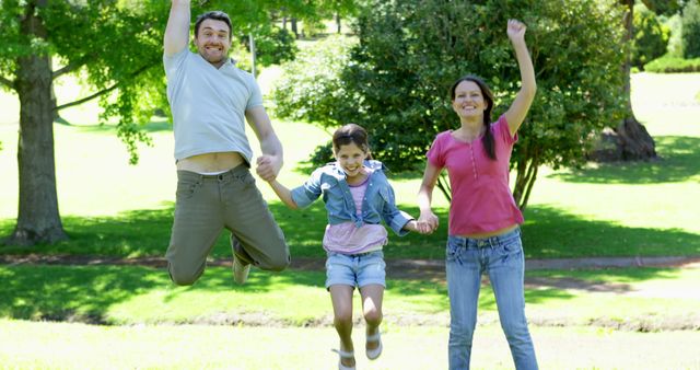 Family of three enjoying quality time outdoors in a green park on a sunny day. Perfect for promoting outdoor activities, family bonding, and healthy lifestyles. Suitable for family-oriented advertisements, blog posts about parenting or family outings, and websites that focus on leisure activities.