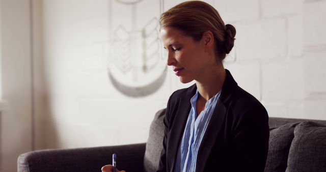 Professional Businesswoman Sitting in Office with Suit and Pen - Download Free Stock Images Pikwizard.com