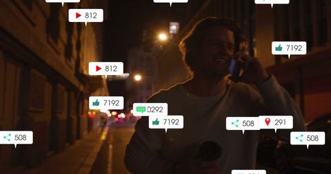 Man Engaged with Social Media on Street at Night
