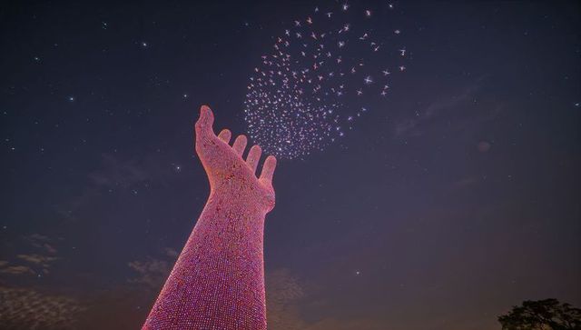 Reaching illuminated hand sculpture releasing glowing drone swarm into starry night sky