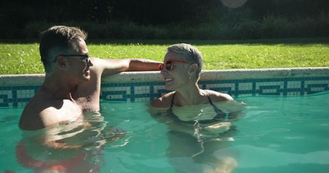 Senior Couple Relaxing and Chatting in Pool, Enjoying Leisure Time