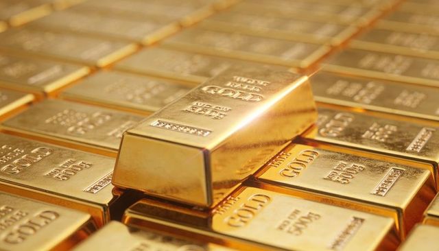 Stacked gold bullion bars shining with single bar resting on top 500g purity hallmarks