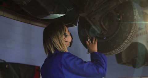 Mechanic Woman Wearing Mask Repairing Car in Garage - Download Free Stock Images Pikwizard.com