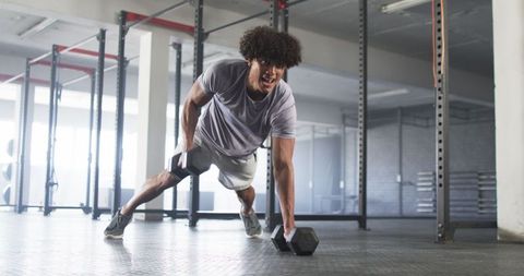 Young man performing intense workout in modern gym environment
