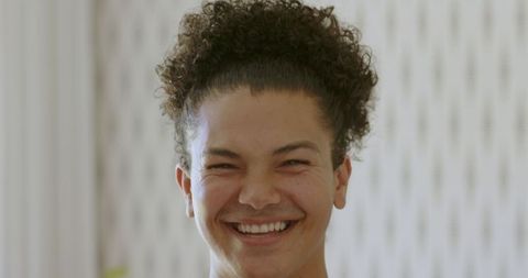 Portrait of young man with curly hair smiling confidently