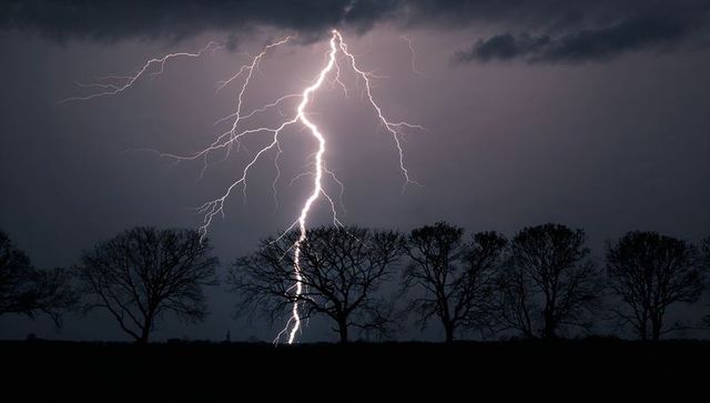 Dramatic Lightning Strikes at Night Over Countryside