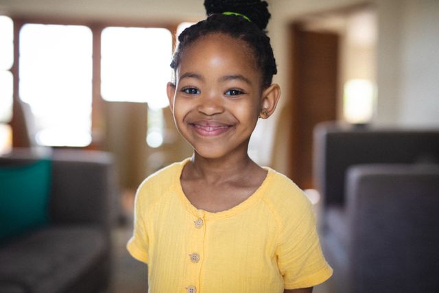 Portrait of smiling cute african american little girl with hair bun at home - Download Free Stock Photos Pikwizard.com