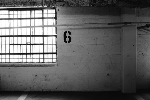 Dimly Lit Parking Garage with Numbered Wall and Window Grates