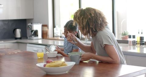 Mother and Daughter Enjoying Breakfast Together in Bright Kitchen