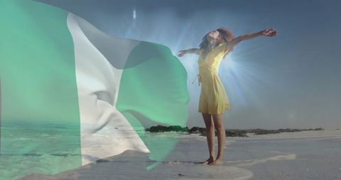 Nigerian flag overlay with woman raising arms on beach at sunflare symbolizing freedom
