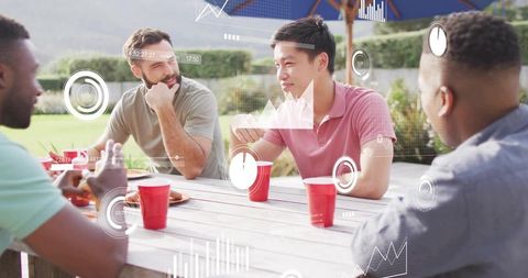 Friends chatting outdoors around picnic table with red cups and casual summer hangout