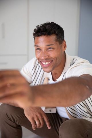 Smiling mid-adult man taking selfie in modern kitchen
