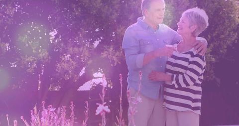 Senior Couple Embracing in Garden During Golden Hour