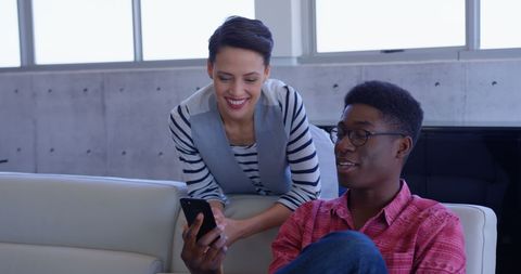 Colleagues Discussing Mobile Technology in Modern Office