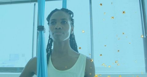 Confident Woman Holding Aerial Hammock in Serene Studio