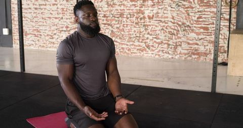 Man Meditating on Yoga Mat in Gym for Wellness and Strength