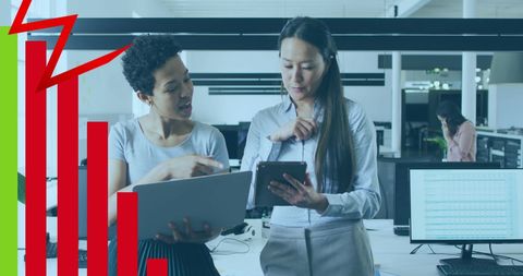 Businesswomen Analyzing Financial Graphs in Modern Office