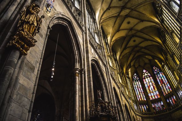 Detailed view of a Gothic cathedral's interior featuring impressive arches and colorful stained glass windows. Perfect for illustrating articles on historical architecture, religious sites, and cultural heritage. Useful for architectural studies, religious tourism, and history documentation.