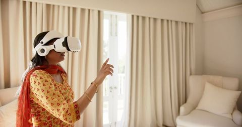 Indian Woman Engaging with VR Headset in Modern Living Room