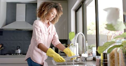 Smiling Woman Washing Dishes in Sunny Modern Kitchen - Download Free Stock Images Pikwizard.com