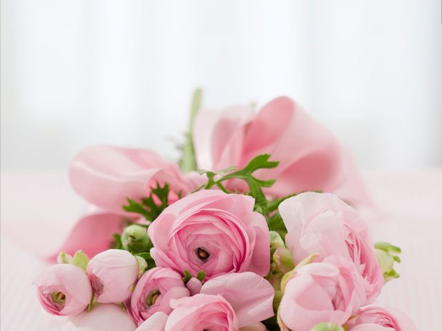 Close-up of a delicate pink rose bouquet with a ribbon, ideal for use in wedding invitations, romantic events, floral-themed advertisements, or greeting cards. The soft focus and pastel colors enhance the sense of romance and celebration, perfect for decor or promotional materials highlighting love and beauty.