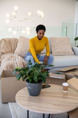 African American Woman Unpacking in Minimalist Living Room