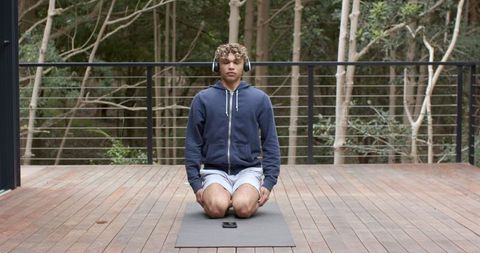 Young Man Meditating Outdoors with Headphones