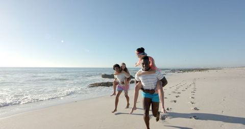 Interracial Friends Enjoying Piggyback Rides by Ocean Shore - Download Free Stock Images Pikwizard.com