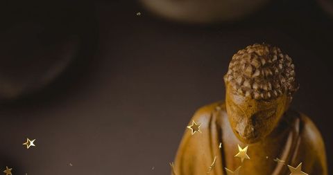 Carved buddha statue with star confetti in meditative harmony
