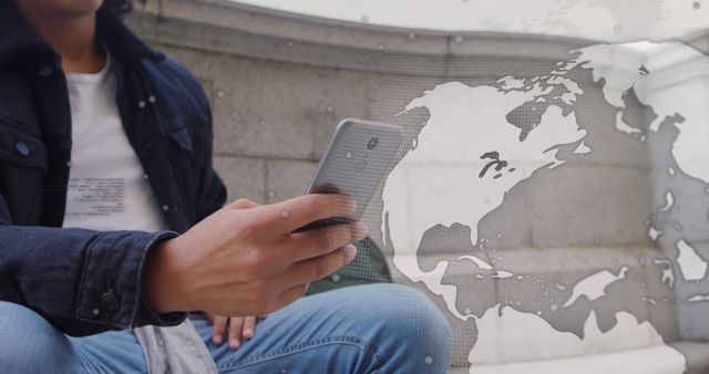 This portrays a young adult using a smartphone with an overlay of a digital world map, illustrating global connectivity and modern communication technology. Ideal for marketing technology products, social media applications, or illustrating global connectivity and digital innovation themes.