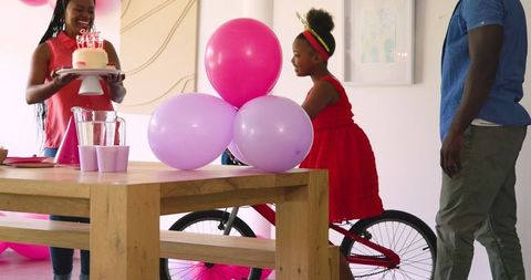 Family birthday celebration with cake and balloons