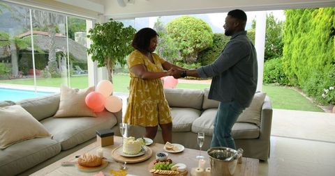 Joyful Couple Dancing Celebrating Special Occasion at Home