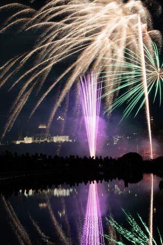 Spectacular night fireworks display with reflections in water