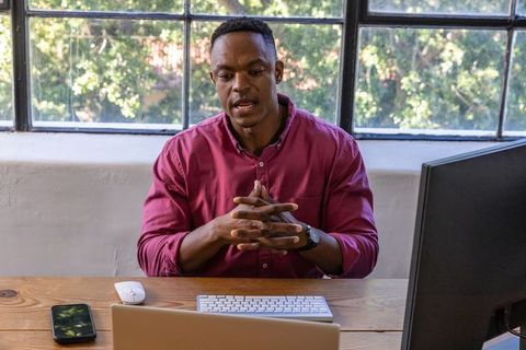 African american businessman leading online meeting from office desk