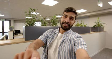 Confident Indian Professional Engaging Camera in Contemporary Office