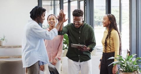 Happy Business Team Collaborating on Tablet in Office