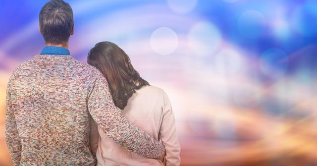 Digital composite of Rear view of man standing arm around woman over blur background