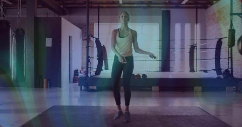 Woman skipping rope in boxing gym for high-intensity cardio and athletic conditioning