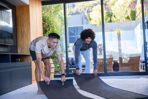 Diverse Friends Preparing Yoga Session in Modern Living Room