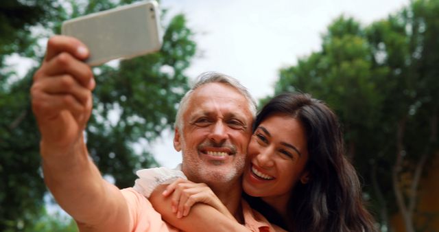 Smiling couple taking selfie in the city