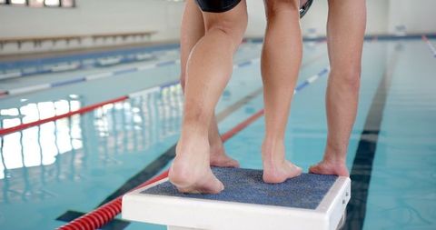 Swimmers prepared on starting block for indoor race