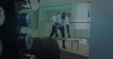 Mature man lifting dumbbells at modern gym