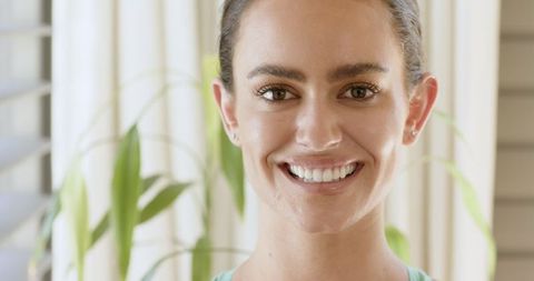 Smiling Woman Posing Indoors by Potted Plant and Blinds