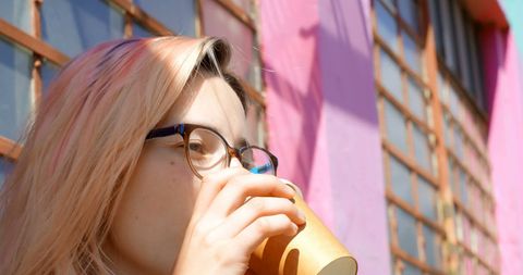 Caucasian Woman Sipping Coffee in Urban Environment