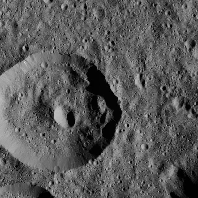 A high-resolution view of the cratered landscape within Meanderi Crater on the dwarf planet Ceres. The image highlights elongated craters potentially formed by slumping material. Ideal for educational content about astronomy, space exploration, or detailed studies of asteroid surfaces.